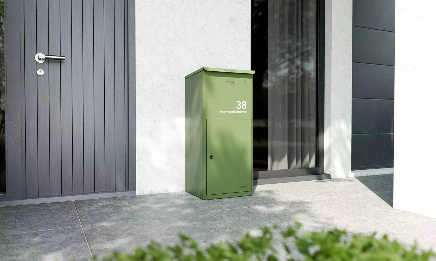 Grön Bravios Brooklyn paketbrevlåda i trädgårdsmiljö